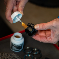 Anwendung des Variolube G11x Polyetherfetts aus der 100-g-Pinseldose auf ein Gewindebauteil